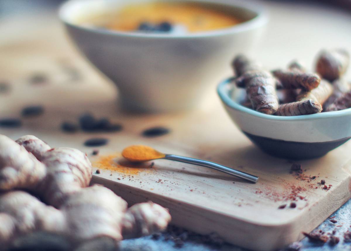 Step-by-step preparation of golden milk with coconut milk showing simmering pot and spice jars