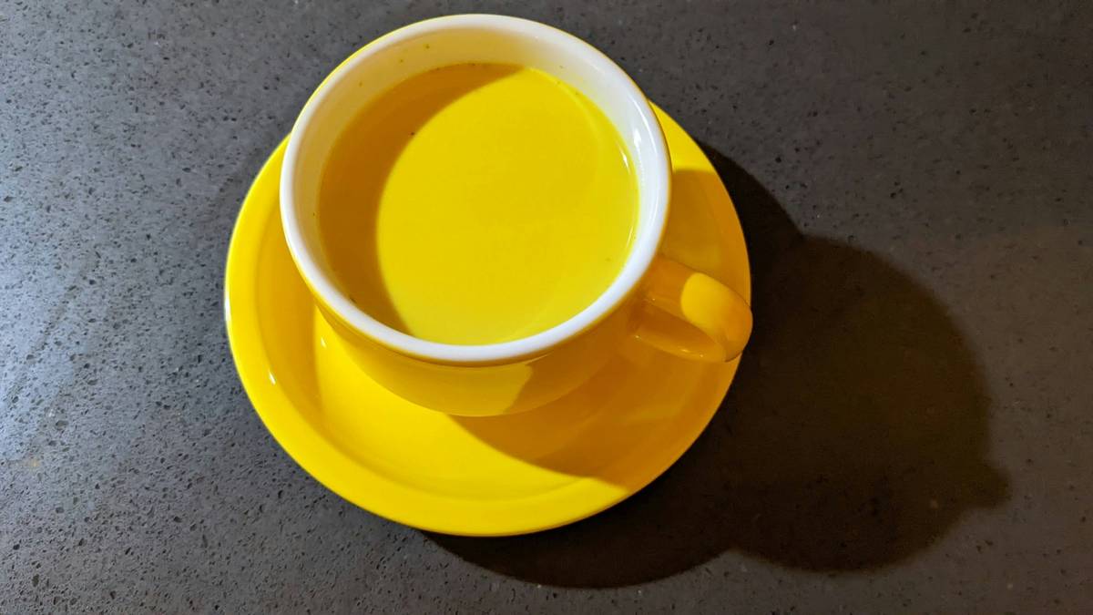 herbal relief with turmeric: golden turmeric root and supplement capsules on wooden table