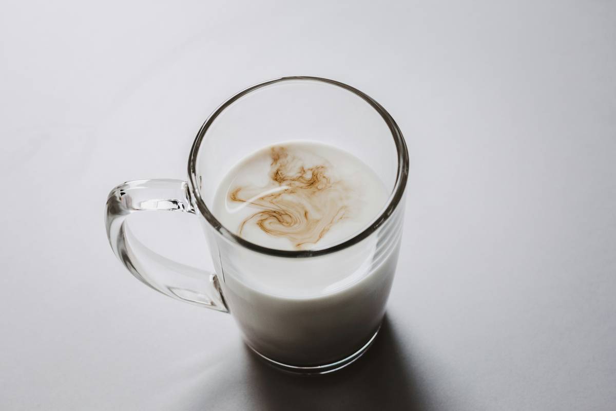 golden milk night time served in a ceramic mug with cinnamon stick and moonlight in background