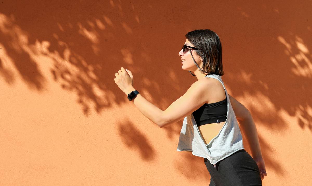 Woman running against an orange wall